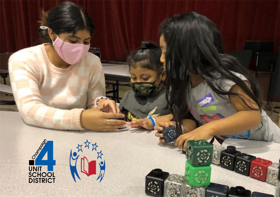 Morelia Lara instructing two small girls, with the district seal and America Reads program seal superimposed on the foreground