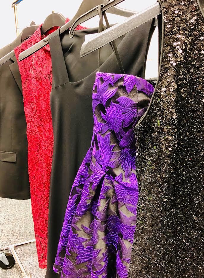 a series of formal dresses hanging on a rack