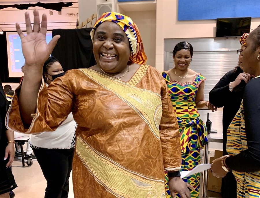 Mrs. Djamba smiling and waving in traditional Congolese dress